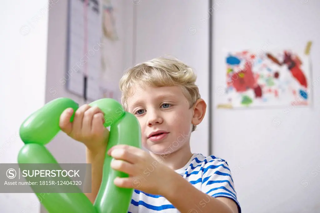 Little boy looking at green balloon