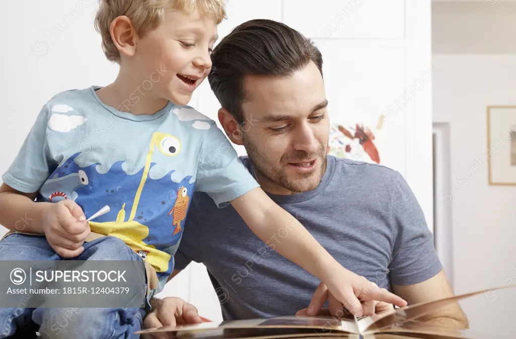 Father looking at photo album with kids