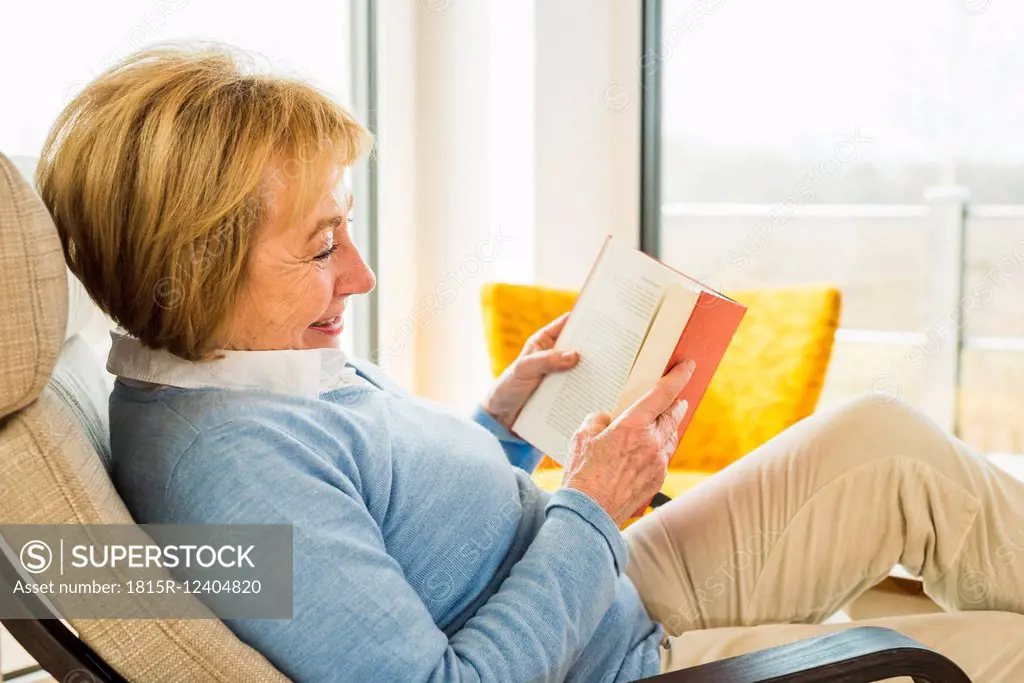 Senior woman at home reading book