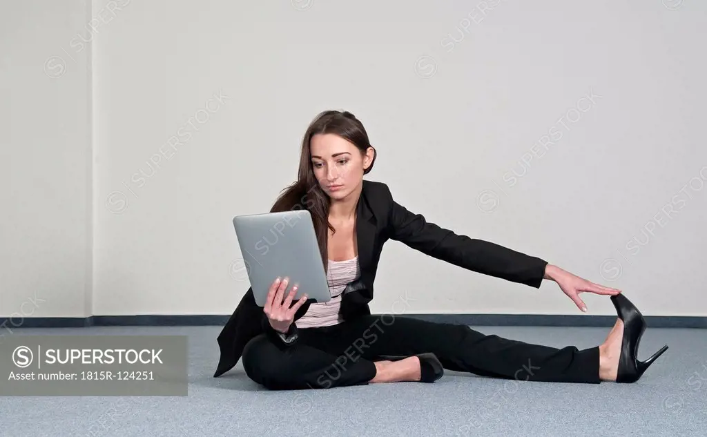 Germany, Berlin, Businesswoman exercising with digital tablet