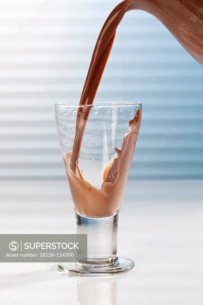 Chocolate milk being poured into glass, close up