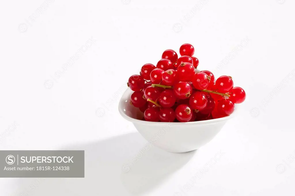 Bowl of red currants on white background, close up
