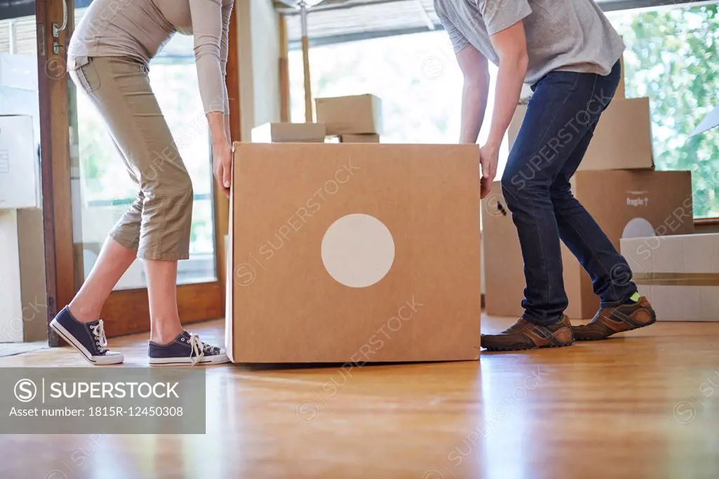 Couple moving house carrying a box