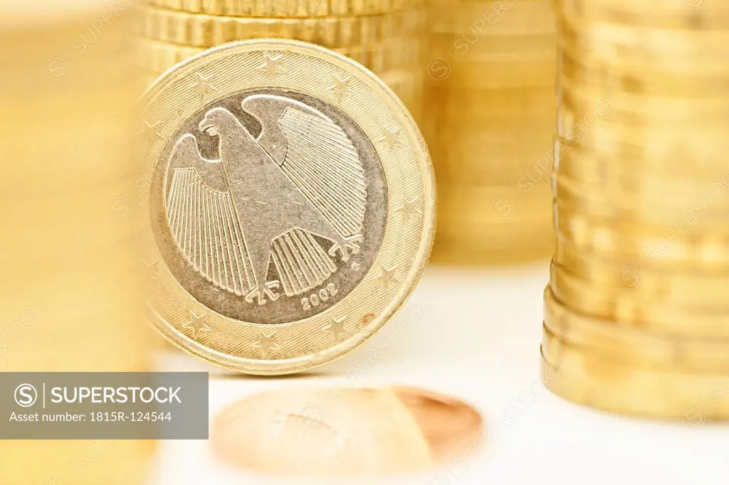 Stacks of Euro coins with One Cent coin, close up