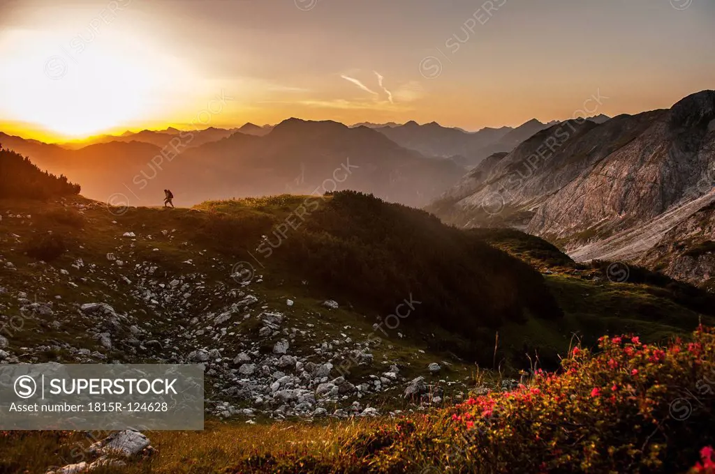 Austria, Salzburg Country, Man hiking through Niedere Tauern mountains at sunrise