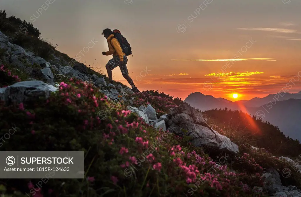 Austria, Salzburg Country, Man hiking through Niedere Tauern mountains at sunrise