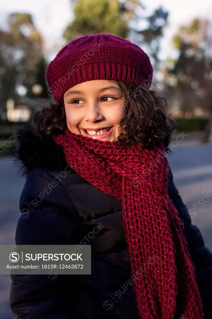 Portrait of smiling little girl wearing wool cap and scarf