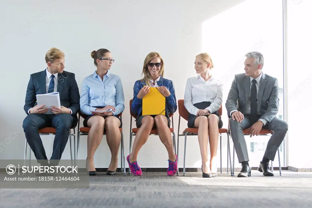 People sitting in a row, waiting for job interview