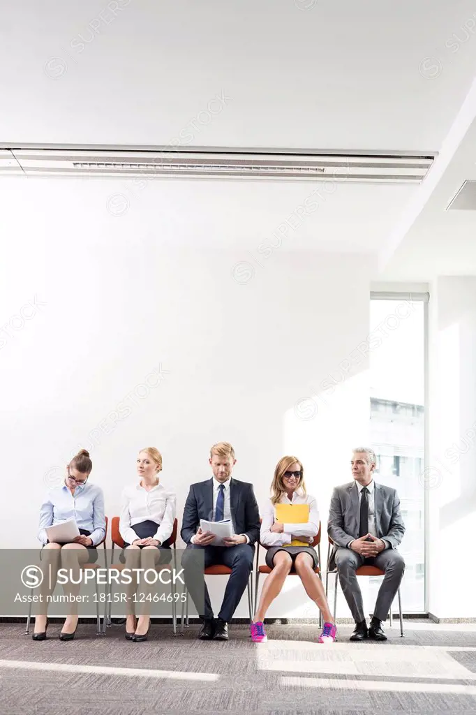 People sitting in a row, waiting for job interview