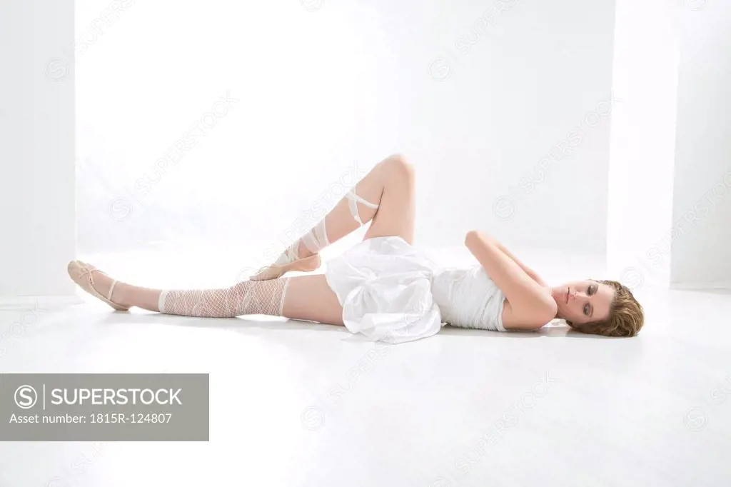 Young ballet dancer relaxing on floor