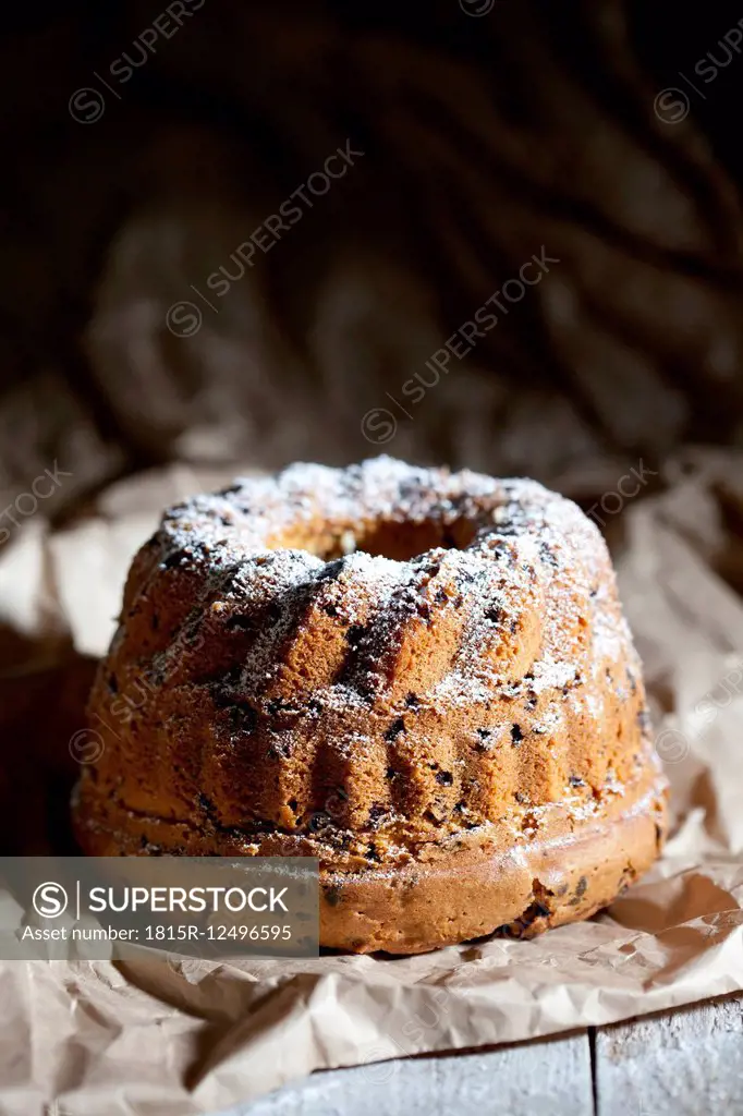 Chocolate cake sprinkled with icing sugar on paper