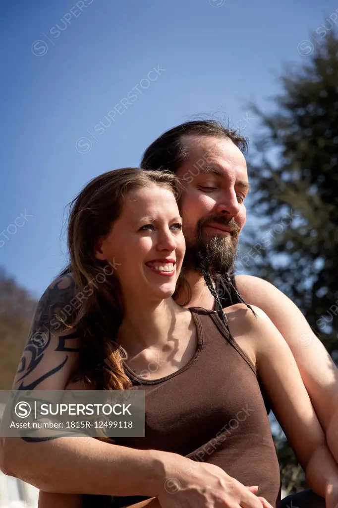Happy man and woman embracing outdoors