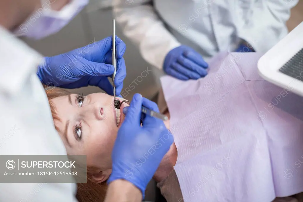 Dentist performing a routne checkup for his patient