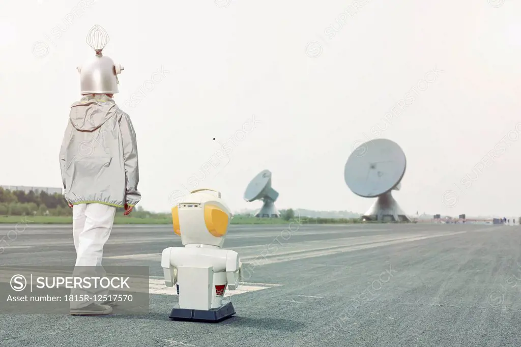 Boy dressed up as spaceman with robot