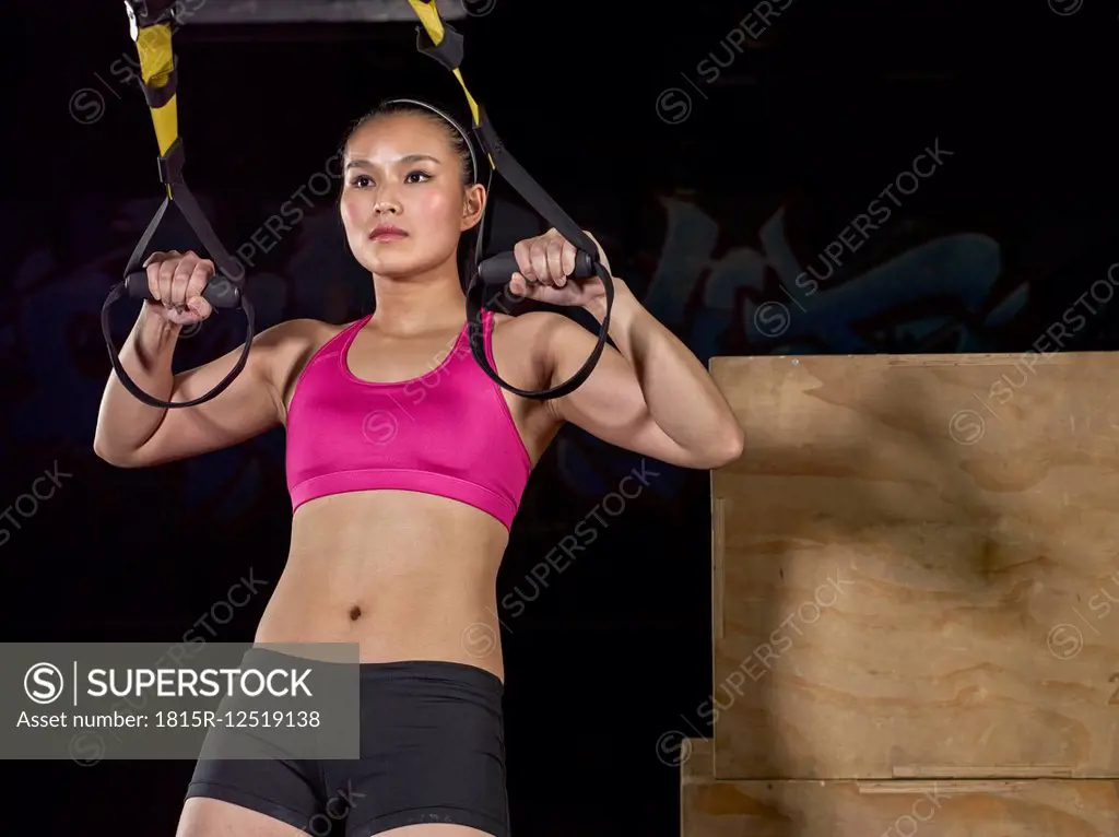 Young woman doing suspension training