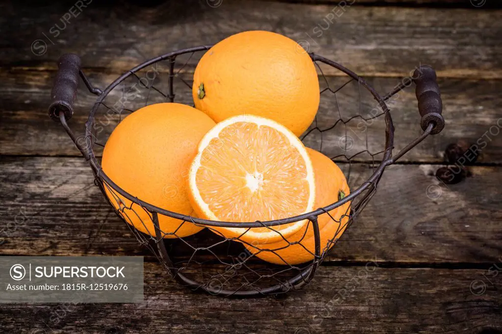 Sliced and whole oranges in a wire basket