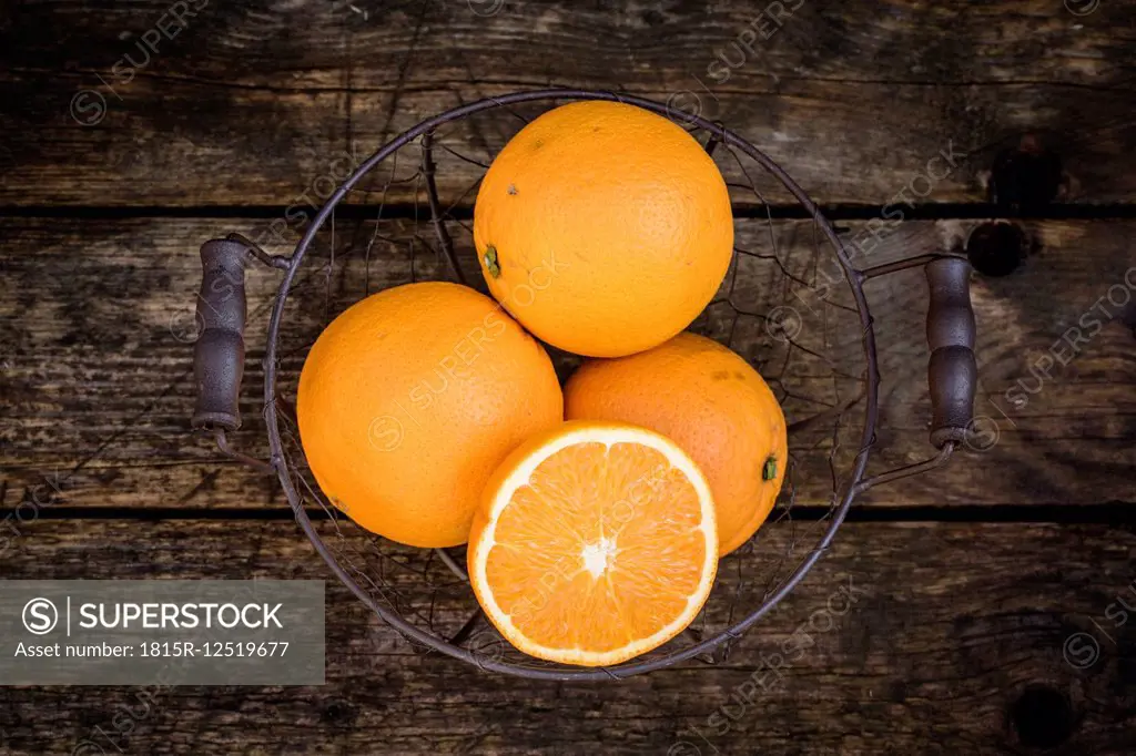 Sliced and whole oranges in a wire basket
