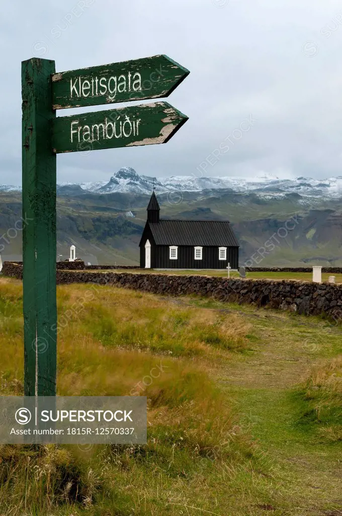 Iceland, Budir, view to church with sign post in the foreground