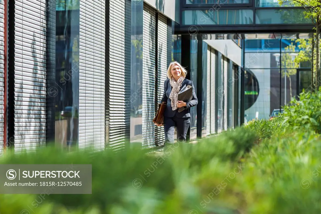 Nature businesswoman carrying briefcase and files