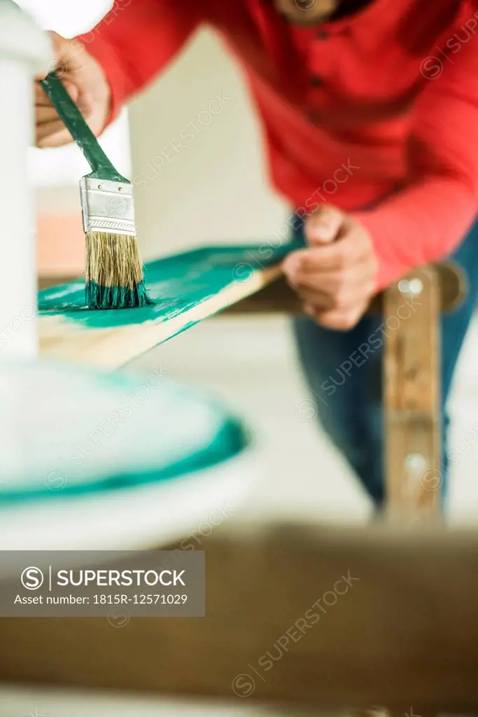 Man painting wooden board