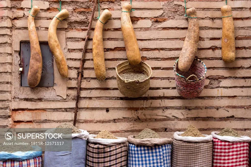 Morocco, Marrakesh, row of calabashes and sacks with spices in front of facade
