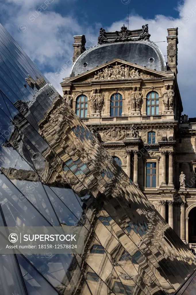 France, Paris, Louvre, view to facade with reflection on glass pyramide in the foreground