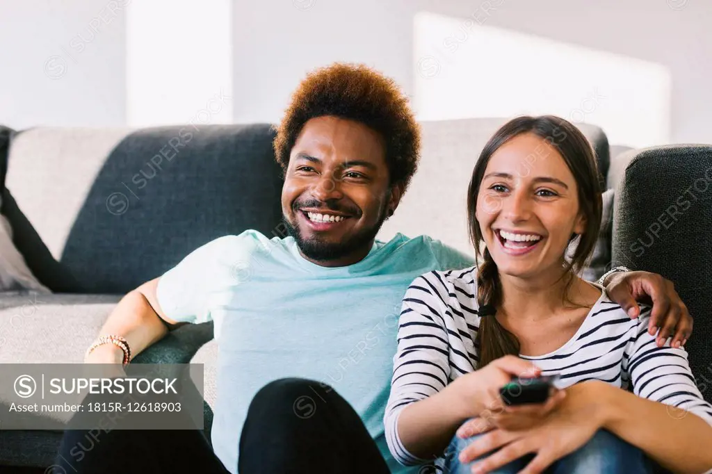 Happy young couple watching TV