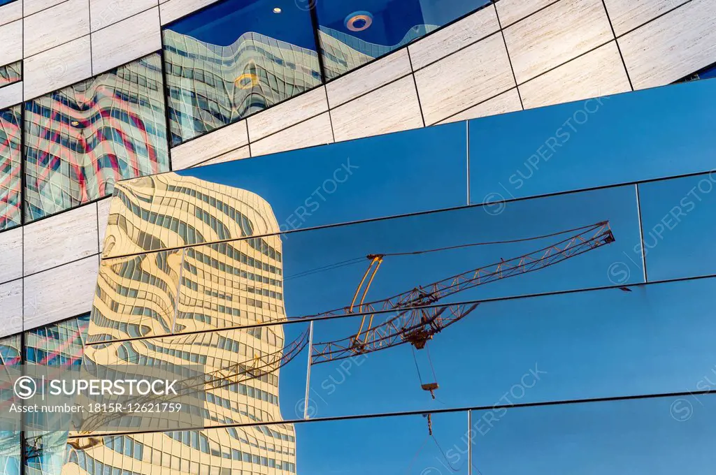 Germany, Duesseldorf, reflections of construction crane and buildings on glass facade of Koe-Bogen