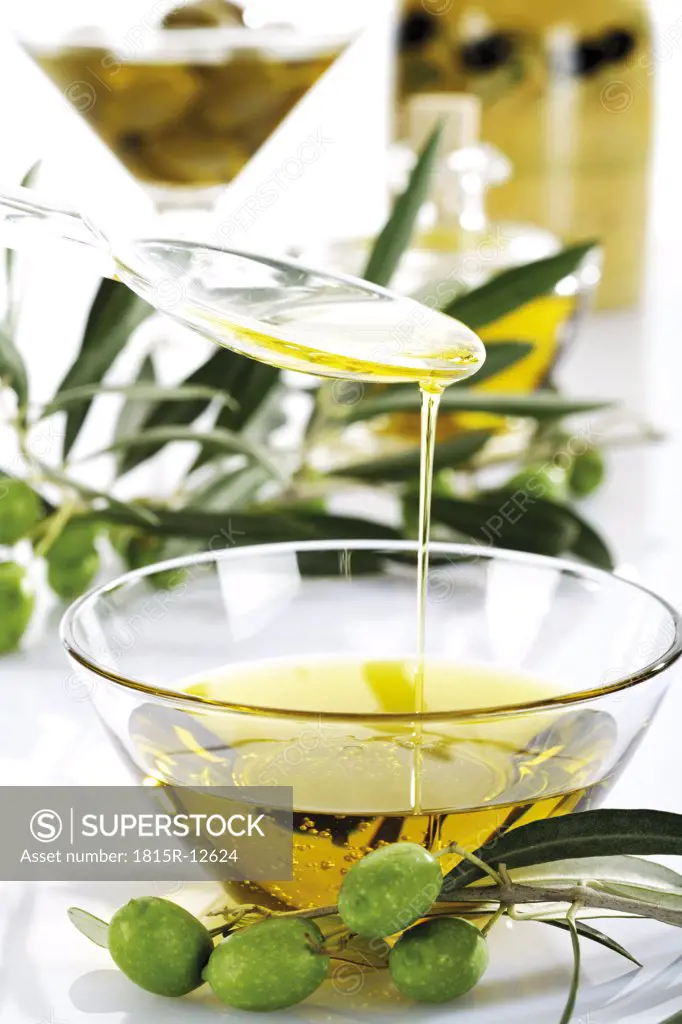 Fresh green olives and olive oil in glass bowl