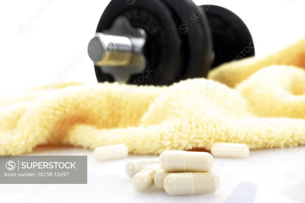 Dumbbell on towel and pills