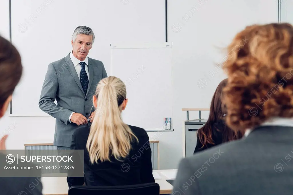 Mature man giving business presentation