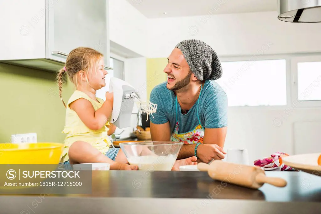 Happy father and daughter baking in kitchen