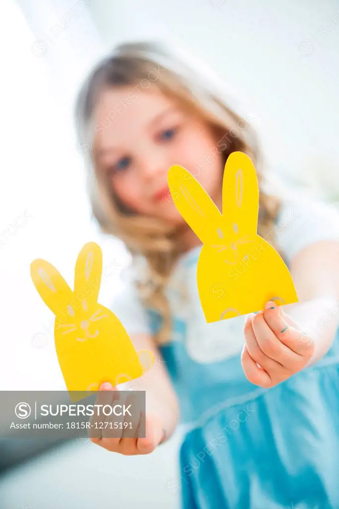Little girl holding paper Easter bunnies