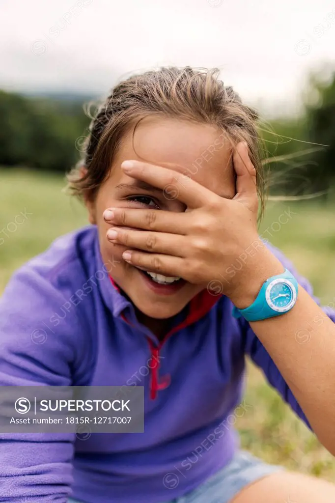 Portrait of girl peeking through her fingers