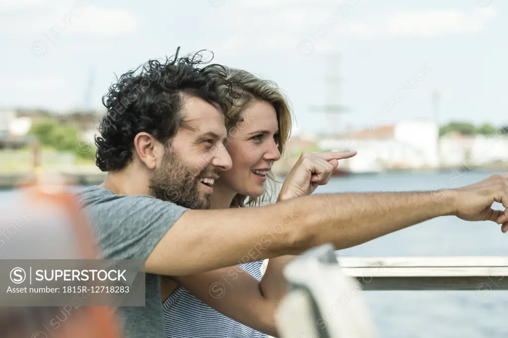 Germany, Luebeck, smiling couple pointing at something