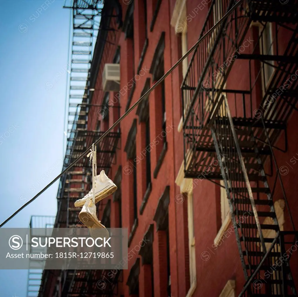 USA, New York City, SoHo, Trainers hanging on electric cable