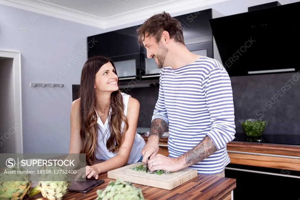 Smiling couple face to face i their modern kitchen