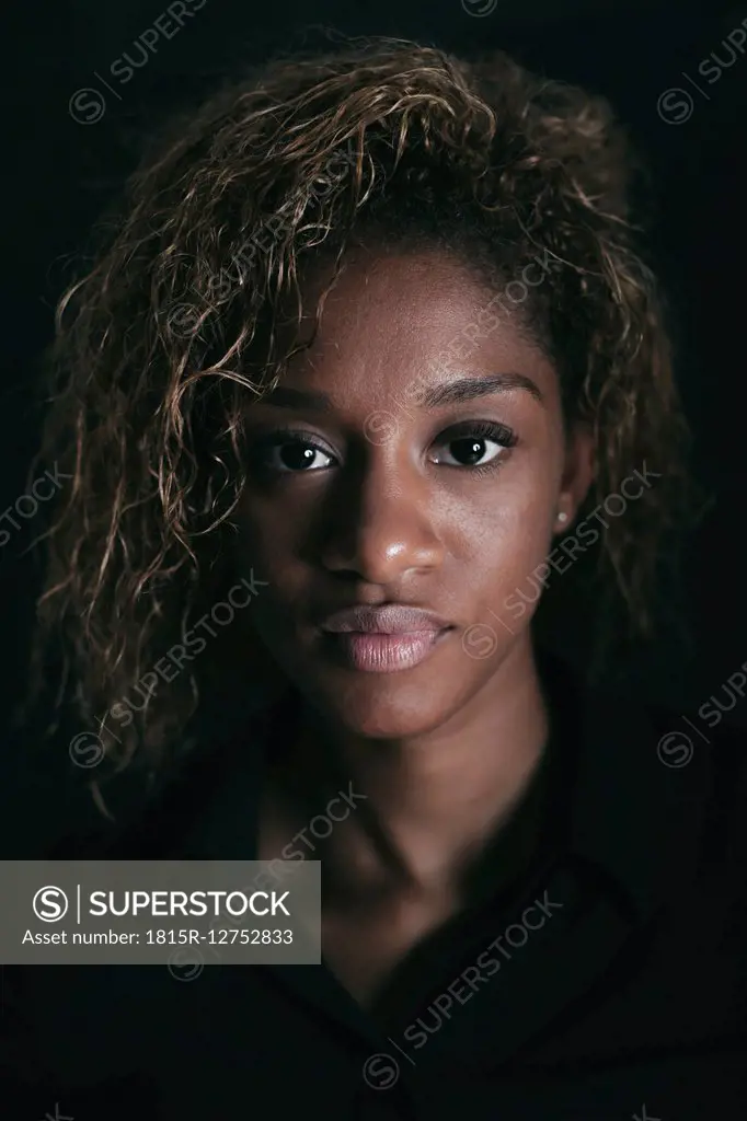 Portrait of attractive young woman in front of black background
