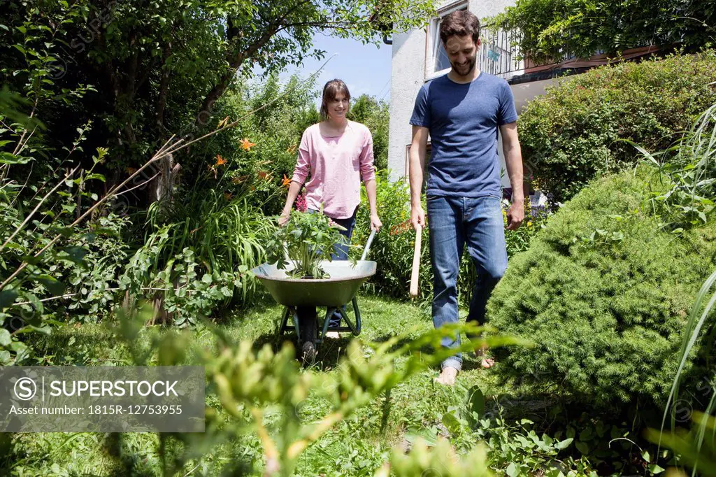 Couple with wheelbarrow gardening together