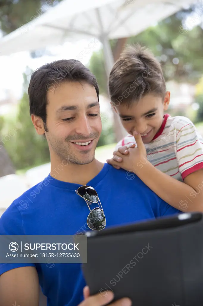 Portrait of father and son with digital tablet