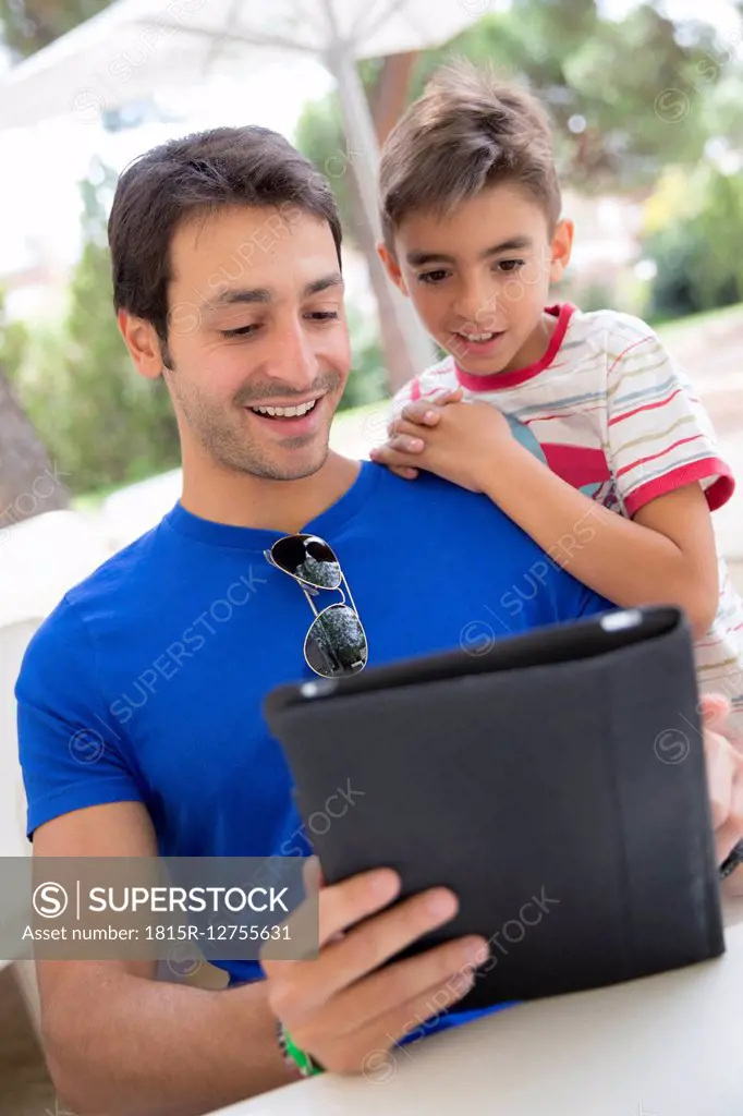 Portrait of father and son with digital tablet