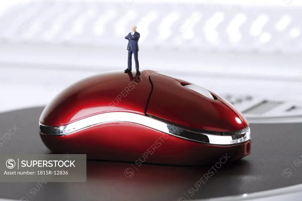 Figurine standing on PC-mouse