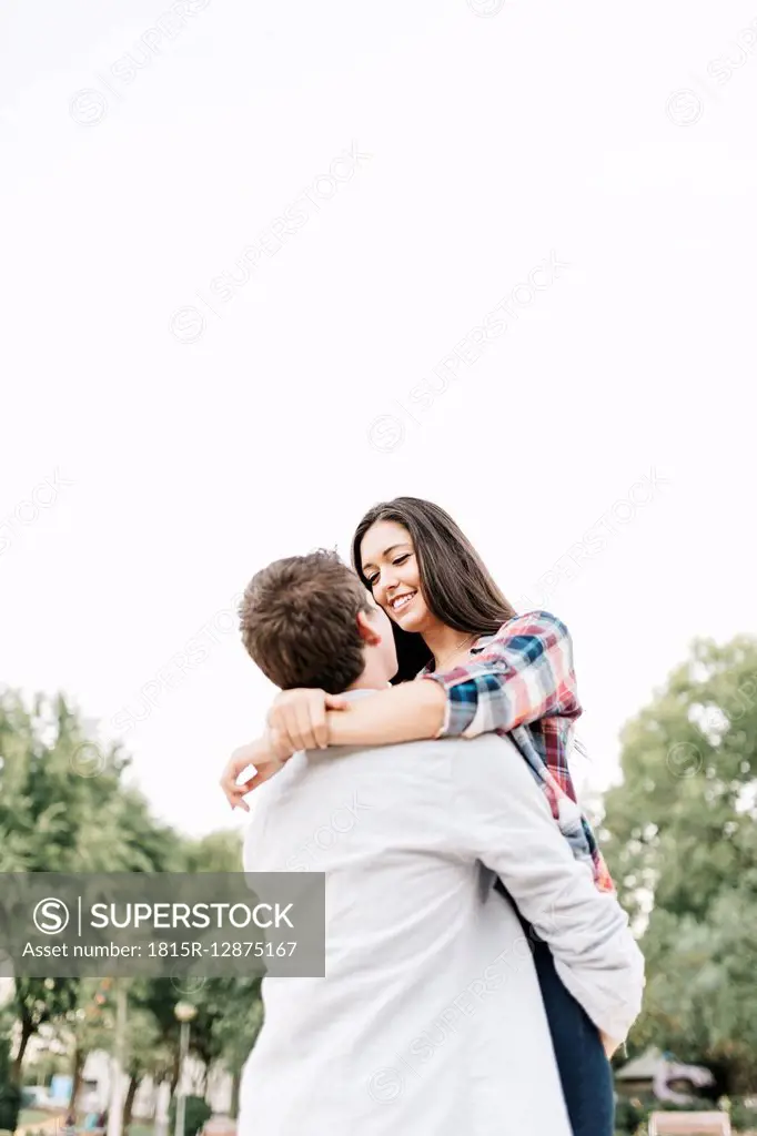 Young couple in love hugging in a park