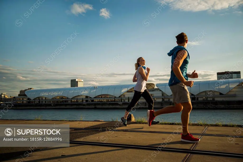 Young couple running by the riverside