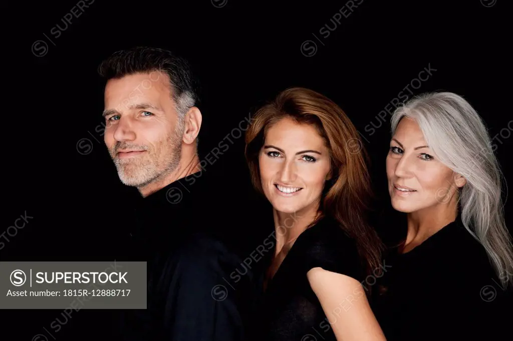 Portrait of three people in a row in front of black background