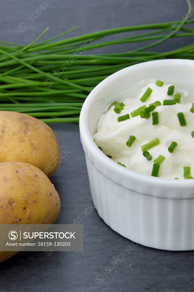 Bowl of curd with potatoes and chives, close up
