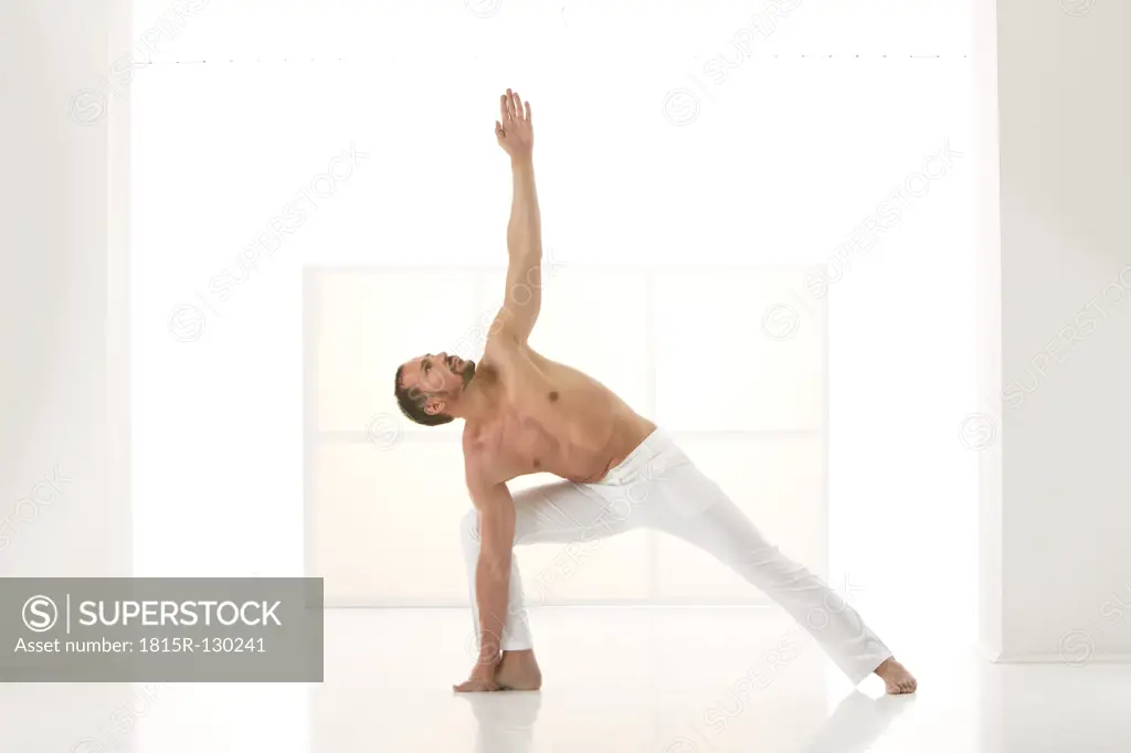 Mature man exercising triangle pose