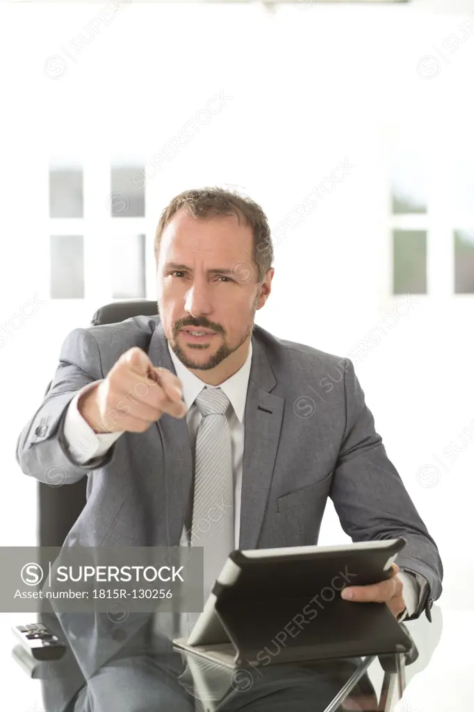 Germany, Portrait of angry businessman pointing