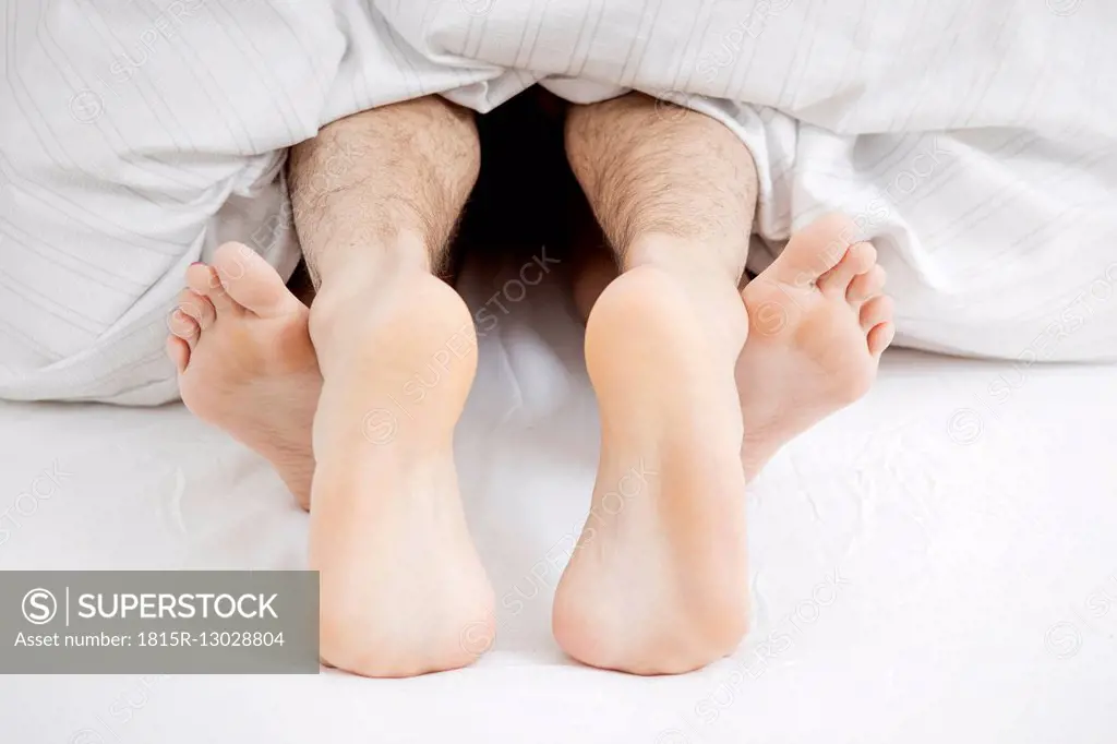 Feet of couple having sex in bed