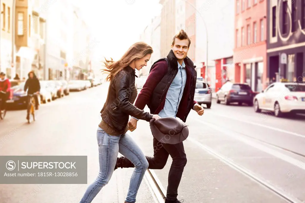 Germany, Berlin, happy couple crossing a street